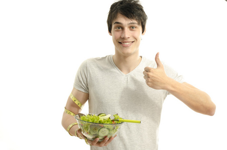 测量他的二头肌有一厘米的同时吃有机健康的沙拉，一个完美的饮食习惯的人。绿色食品健康生活