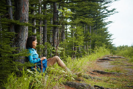 femme de randonneur repose prs des arbres在树旁边休息的徒步旅行者的女人