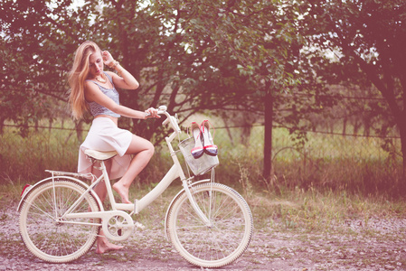在乡村道路上骑自行车的年轻女子