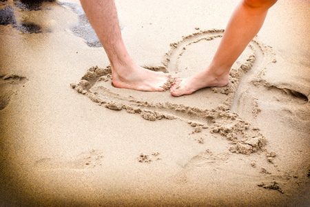 夫妇的腿在沙滩上
