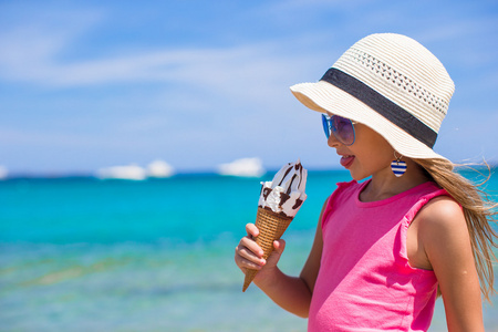 在地处热带的海滩上吃冰淇淋的小可爱女孩