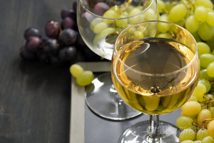 白葡萄酒和什锦的葡萄在黑板上的玻璃