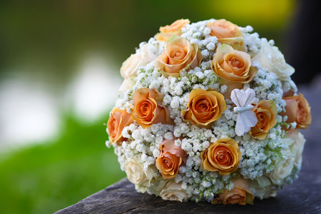 婚礼新娘捧花的躺在木地板上的橙色玫瑰