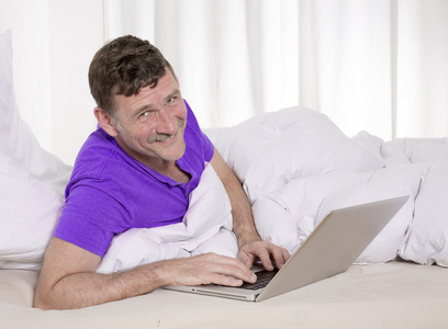 男人在床上笔记本电脑