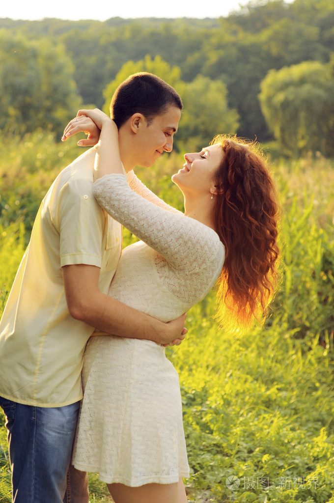 在田野里拥抱几个年轻的爱人