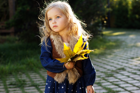 可爱的小女孩，与秋天叶子在公园里