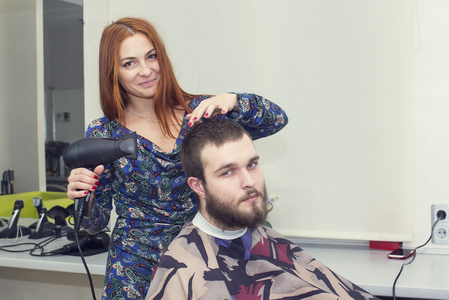 在沙龙的女理发师切割客户的头发