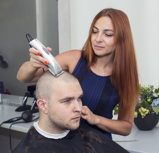 在沙龙的女理发师切割客户的头发照片