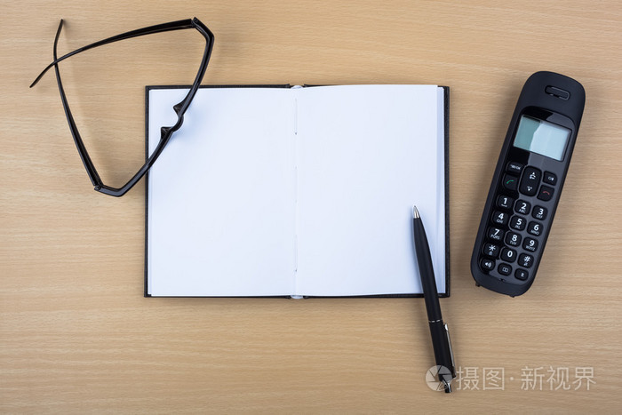 打开笔记本和木质纹理,黑色的电话