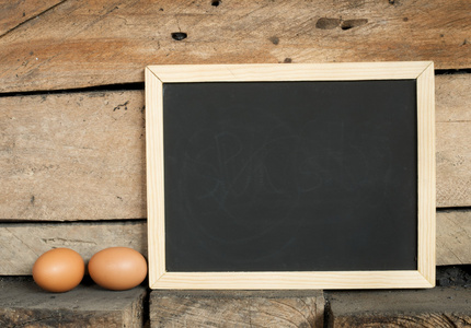 黑板和鸡蛋木制背景