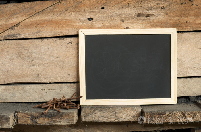 黑板和生锈的钉子上木制背景