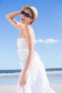 海滩上穿着白裙子戴着太阳帽的金发美女