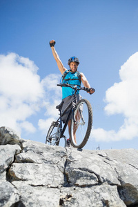 健康人骑着自行车在岩石地形上欢呼