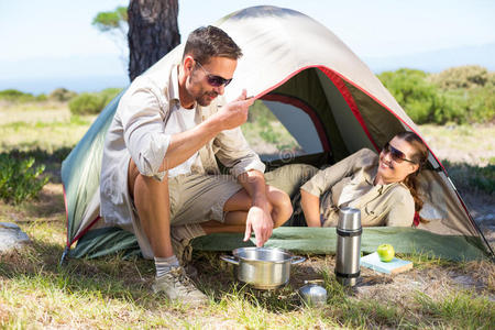 户外情侣在帐篷外的野营炉灶上做饭