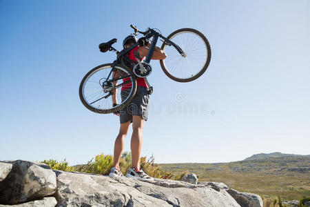在多岩石的地形上骑着自行车的健康人