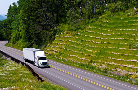 绿山公路上的白色半卡车拖车