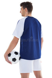 穿着蓝色衣服的足球运动员拿着球站着