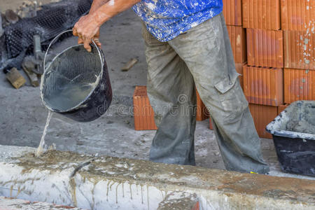建筑工人用一桶水润湿混凝土