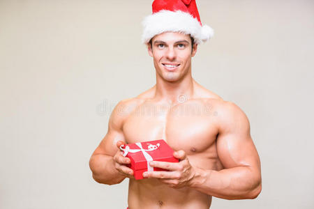 一个的男人，戴着圣诞帽，手里拿着礼物