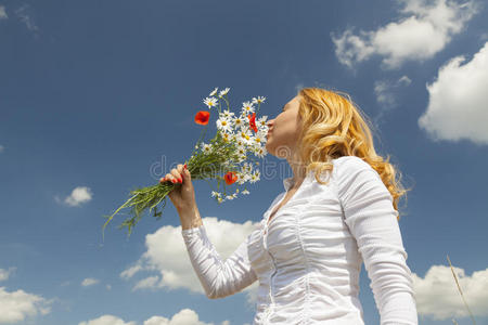 一个三岁小女孩的肖像在花园里闻花香年轻女子走在盛开的向日葵地里