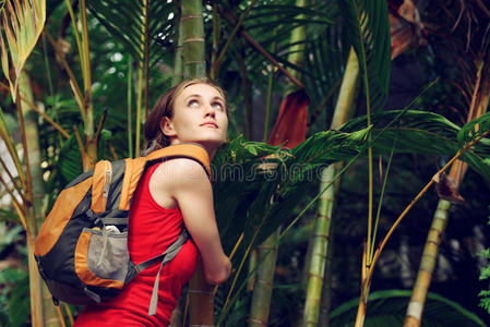 背着背包在热带森林散步的年轻游客