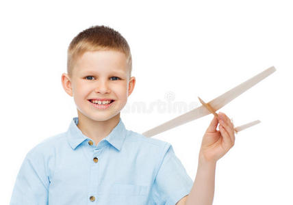 微笑的小男孩拿着一个木制飞机模型