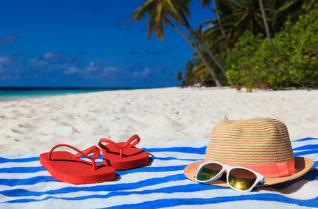 帽子，太阳眼镜和拖鞋在热带海滩上