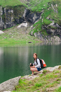 背着背包坐在山上的年轻女子徒步旅行者