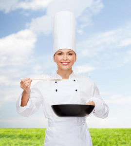 面带微笑的女厨师，带着锅和勺子