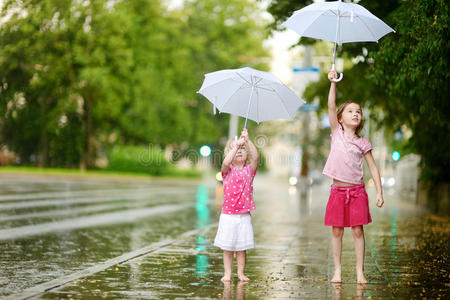 两个可爱的小妹妹在雨中玩耍