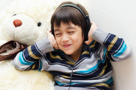 小男孩戴着耳机听音乐