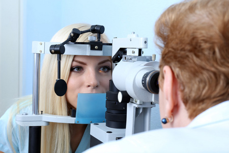 验光概念   年轻漂亮的女人，有她的眼睛由眼科医生检查身体