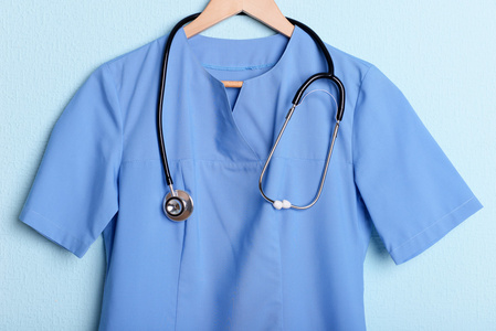 医生用听诊器在蓝色背景上的衣架上衬衫