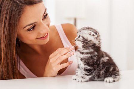 小猫和年轻的女人坐在桌子上