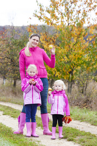 母亲和女儿在秋季自然与苹果