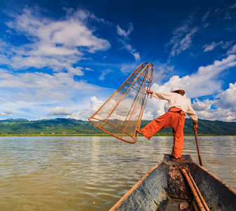 渔民在船上被传统网抓鱼
