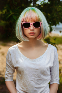 美丽的女孩，在海滩上的粉红框眼镜的肖像