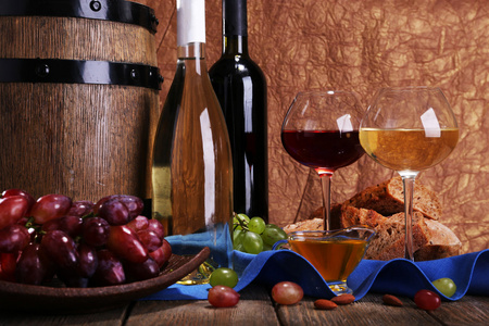 晚饭组成的卡门培尔奶酪和干酪奶酪 蜂蜜 酒和餐巾纸放在木制的桌子上棕色背景上的篮子和酒桶上的葡萄