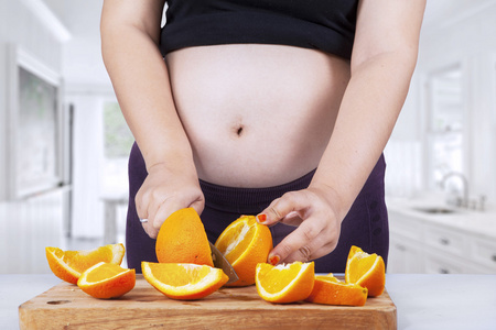 怀孕的母亲和橙色水果