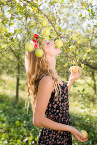 金发碧眼的女人吃黄色的苹果从树上
