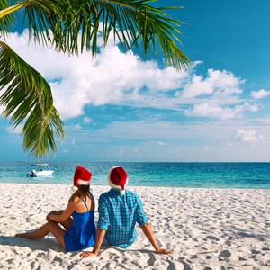 在圣诞节情侣在热带的海滩上