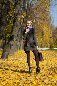 年轻女子走在秋天的公园
