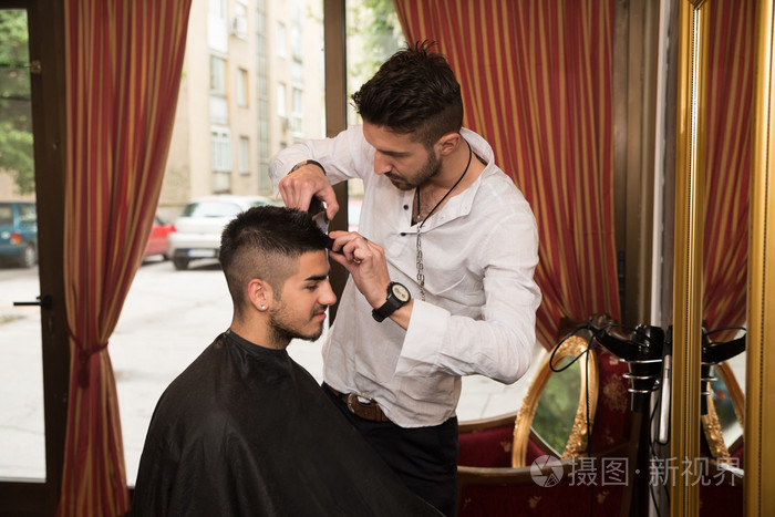 对年轻人进行理发的理发师