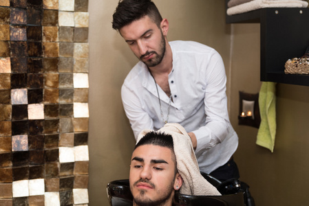 清洗的男人头在理发店的理发师