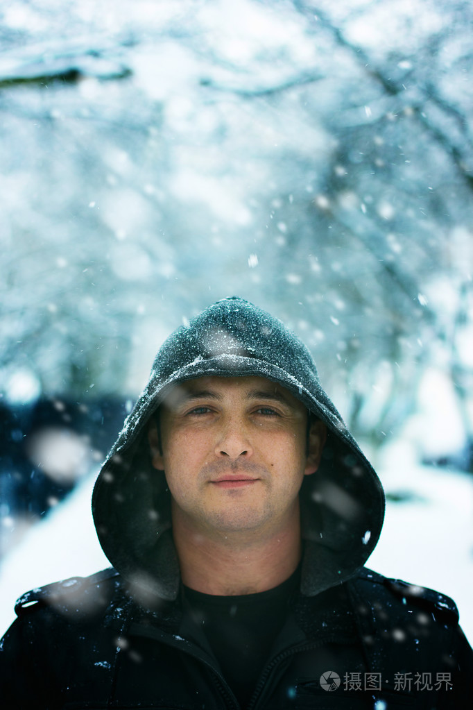 冬天的男子在雪地里穿着罩肖像