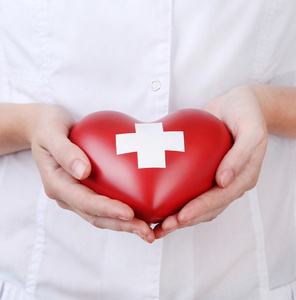 红色的心与十字标志在医生手里,特写照片