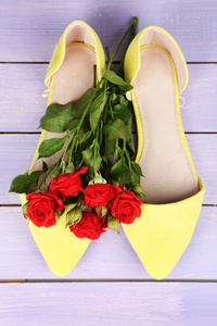 美丽的女人鞋子上面放着木制背景花