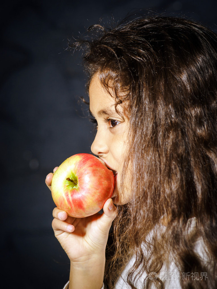 可爱的非洲裔美国人小姑娘与红苹果