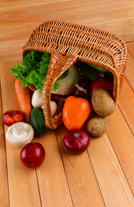 新鲜有机蔬菜在木制的背景上的柳条篮子里