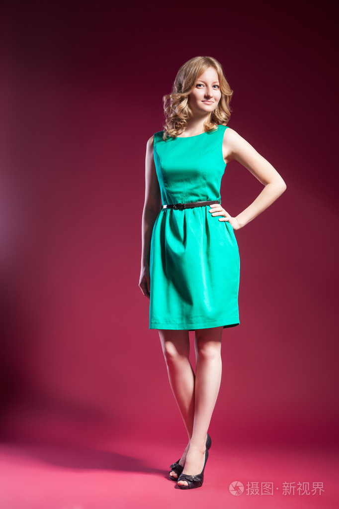 穿着绿色赤脚站在红色的女人